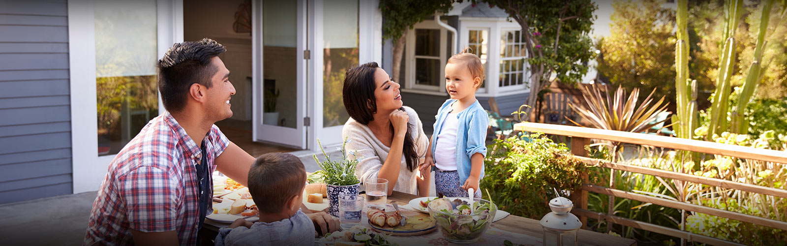 Family of four enjoying breakfast in the backyard