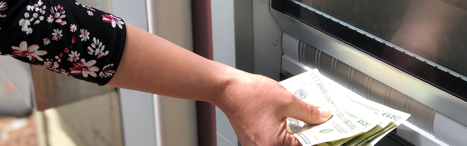 Woman putting money into ATM